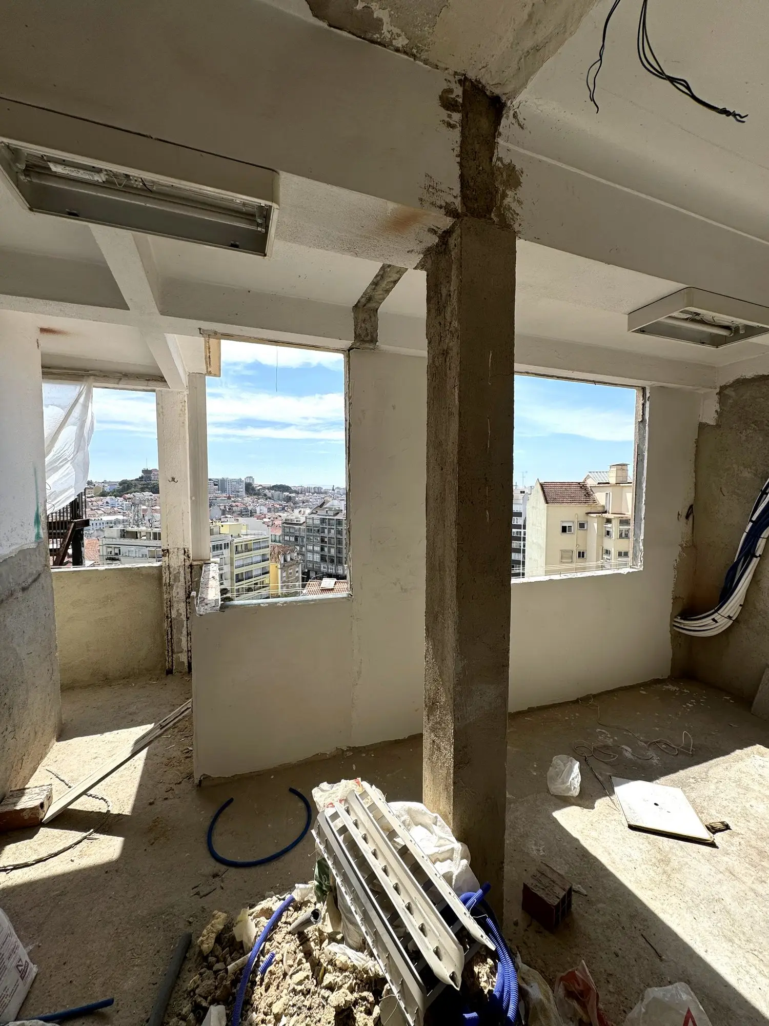 Estrutura da obra a descoberto no último andar do prédio, com vista sobre os telhados de Lisboa