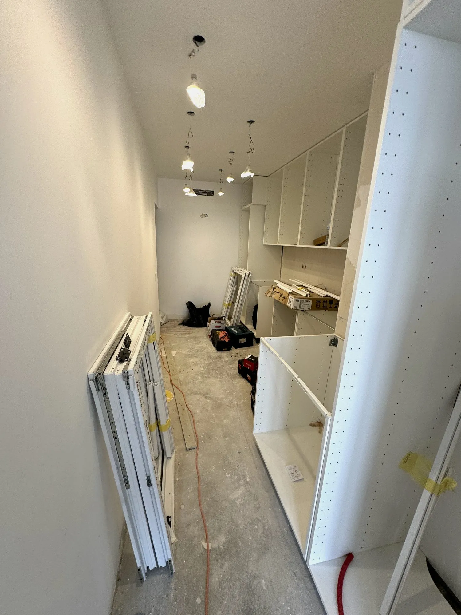 Armários de cozinha e caixilhos das janelas novas à espera de montagem