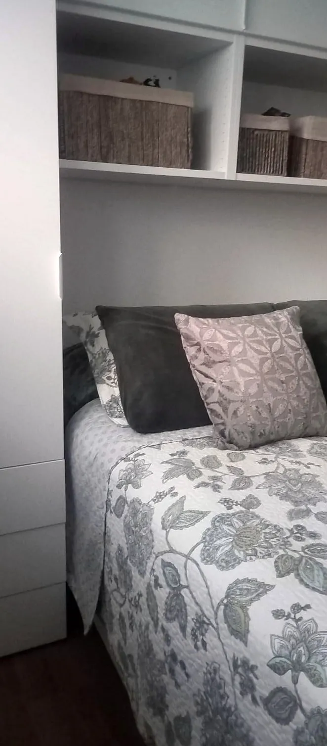 Quarto com armários e prateleiras embutidas por cima da cama