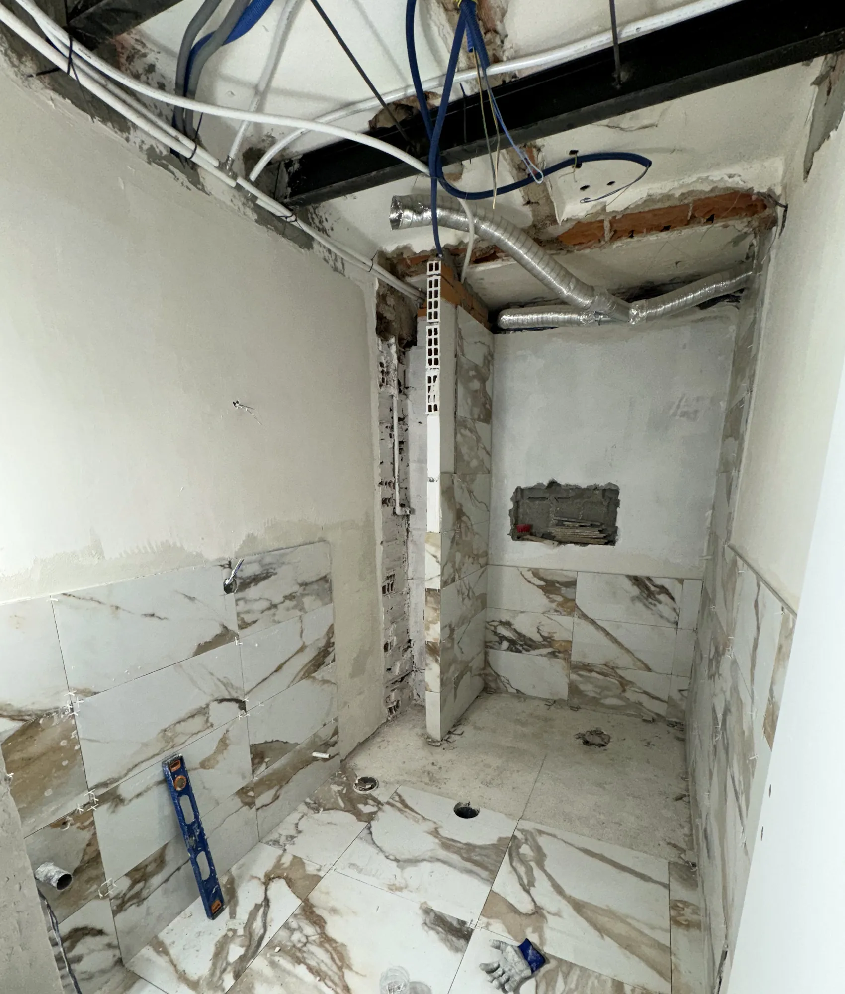 Aplicação do revestimento marmoreado nas paredes e no pavimento da casa de banho