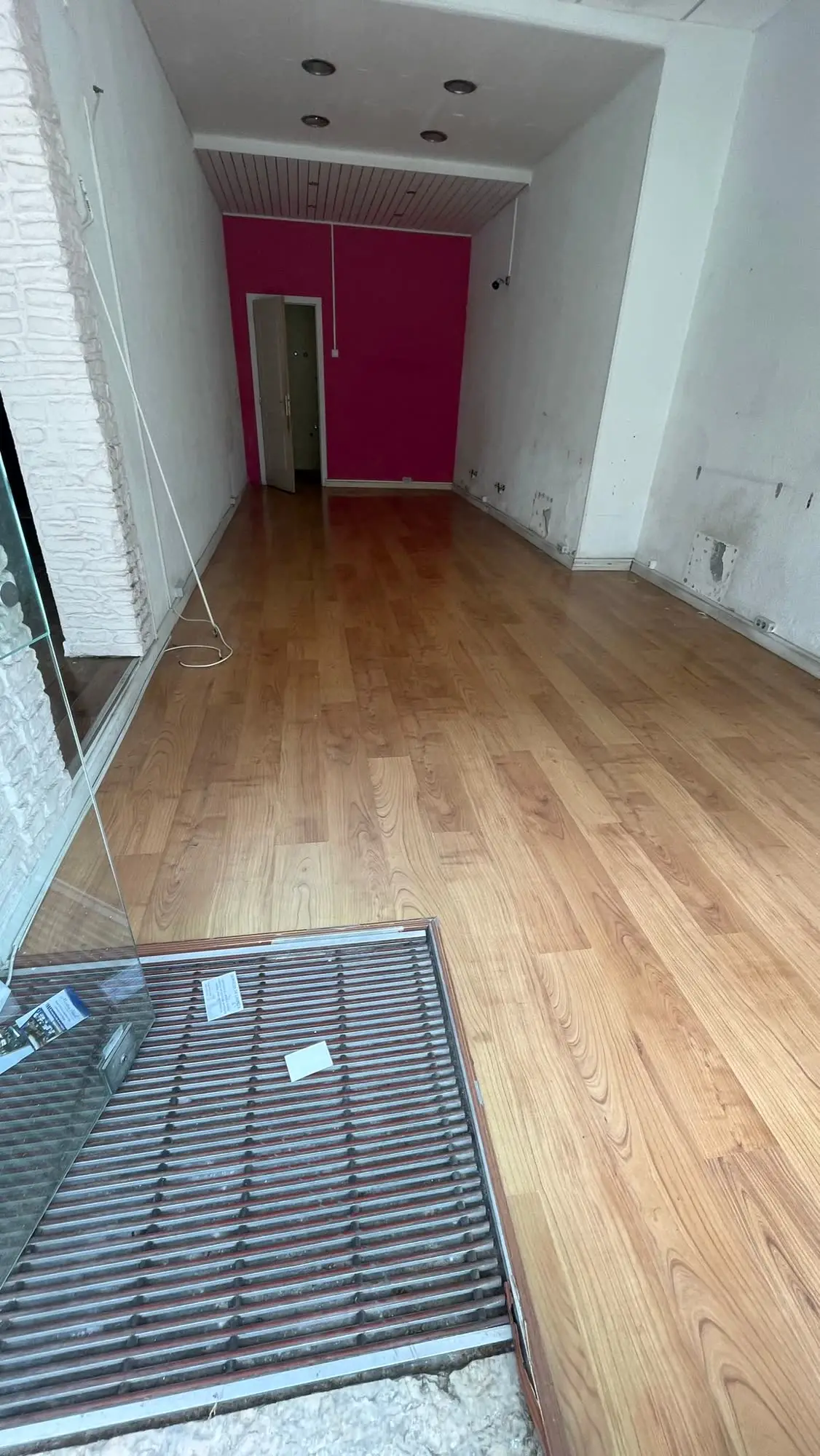 O espaço tal como foi recebido: vazio, com o pavimento existente que se manteve e a parede do fundo ainda pintada de rosa
